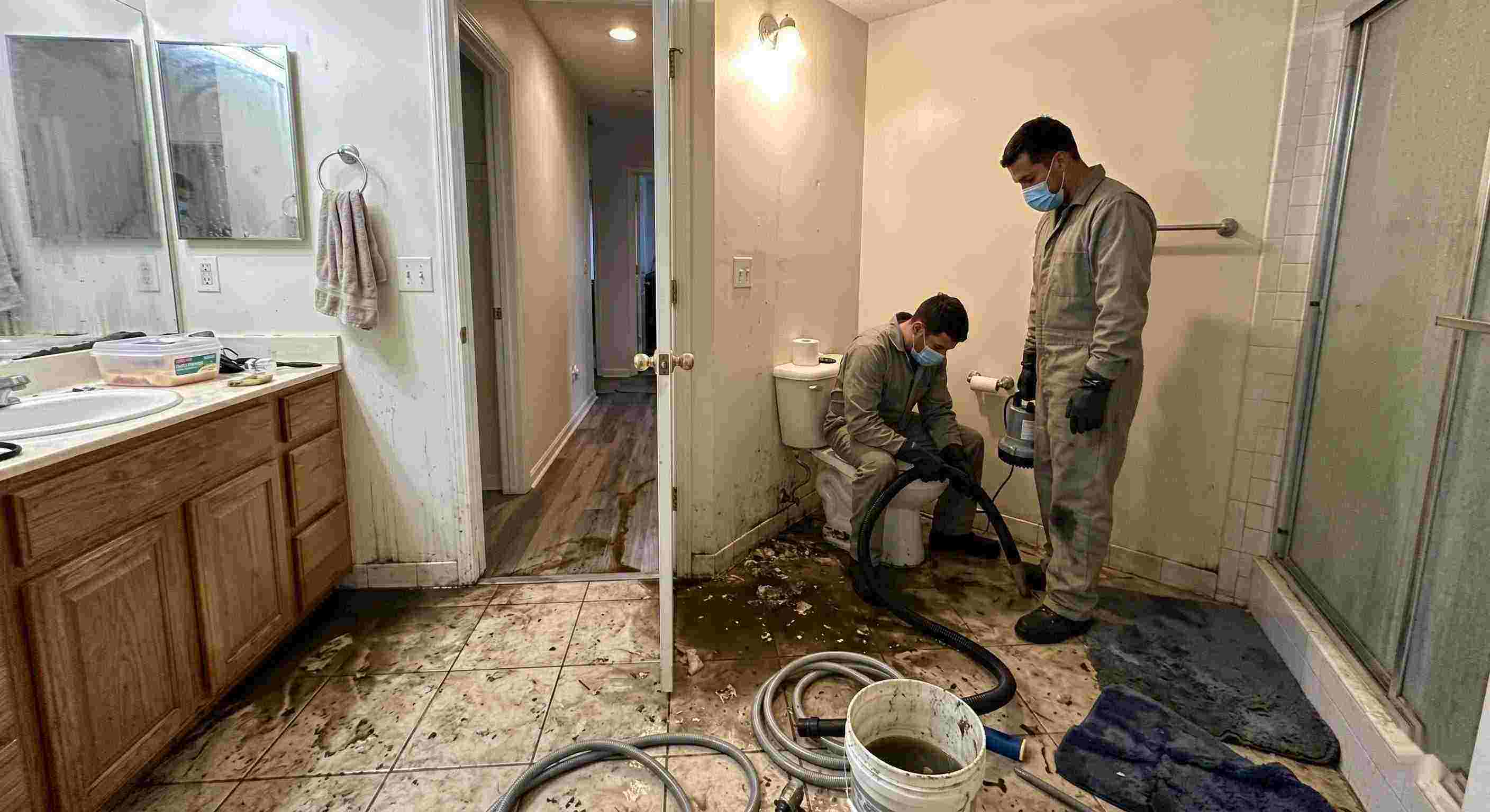 Septic tank backup cleanup in Salt Lake City bathroom with technicians removing contaminated water and sanitizing affected areas